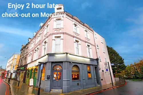 a pink building on a street with a sign on it at Church Street Hotel by Belvilla near King's College Hospital in London