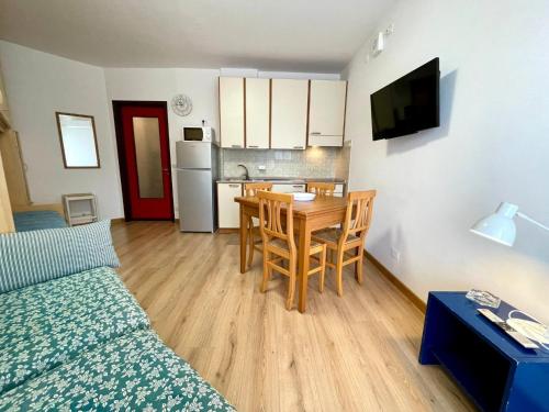 a room with a bed and a table and a kitchen at Functional studio by the beach-Beahost in Porto Santa Margherita di Caorle