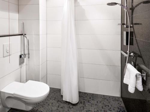 a bathroom with a toilet and a shower at B&B Hotel Offenbach-Süd in Offenbach