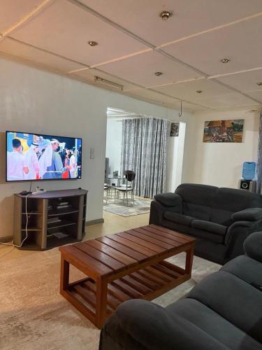 a living room with two couches and a flat screen tv at Serene stays in Kitale