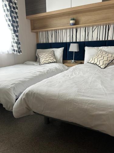 two beds sitting next to each other in a bedroom at Blissful Lodge Haven Lakeland in Flookburgh