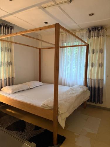 a bedroom with a canopy bed with a window at Serene stays in Kitale