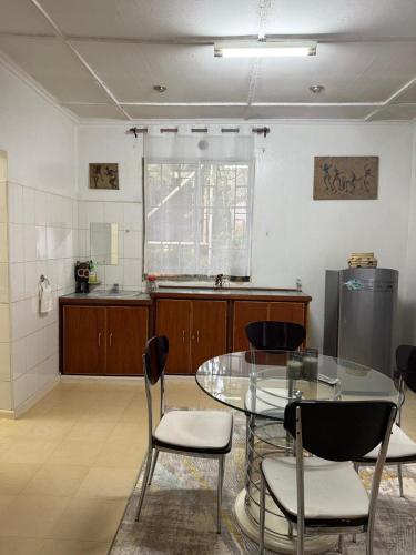 a kitchen with a glass table and chairs in a room at Serene stays in Kitale