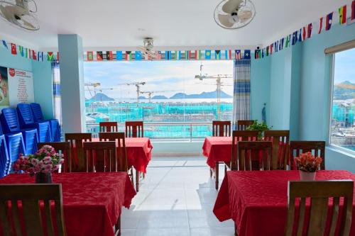 カットバ島にあるPhoenix Flower Hotel & Travelの景色が見える赤いテーブルと椅子のあるダイニングルーム