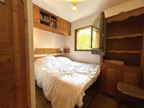 une chambre avec un lit dans une pièce avec une fenêtre dans l'établissement Charmant T2 cabine avec jardin et parking près de Serre Chevalier - FR-1-330F-243, au Monêtier-les-Bains