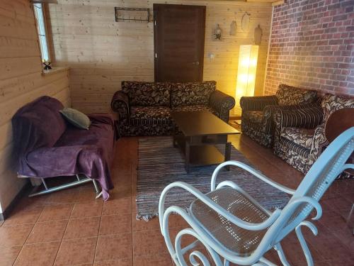 a living room with couches and a table and chairs at Agroturystyka Leśna Malinka in Celejów