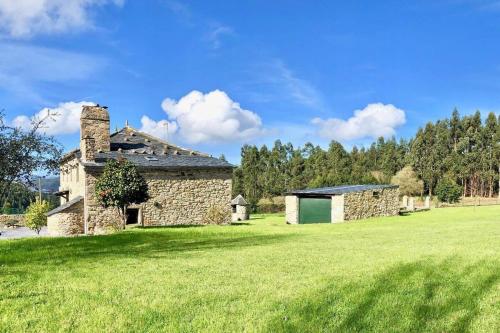 an old stone building in a grass field at The Cliffs - Cottage Xilloi Beach in O Vicedo