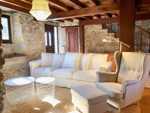 a living room with a white couch and two chairs at The Cliffs - Cottage Xilloi Beach in O Vicedo