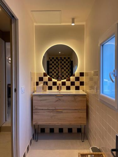 a bathroom with a sink and a mirror at Maison rénovée Lacanau Ocean in Lacanau