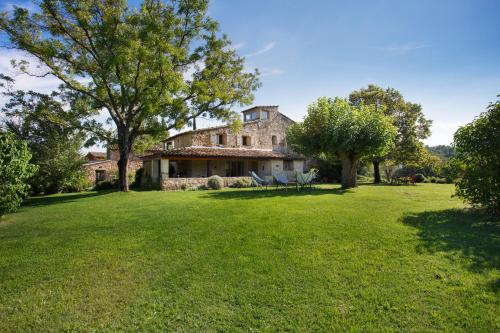 a house with a large yard with two chairs at Domaine Les Petites Vaines in Goult