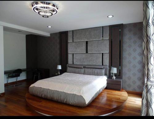 um quarto com uma cama grande e um lustre em relex banglo em Semenyih