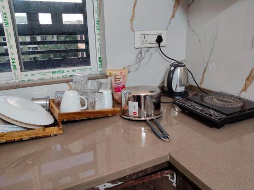 a kitchen counter with a coffee maker and a toaster at Neon Ventures Comfort Stay in Kolkata
