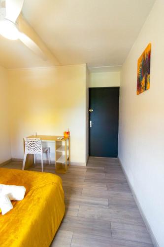 a room with a bed and a desk and a table at Emeraude & Lagon in Pointe-à-Pitre