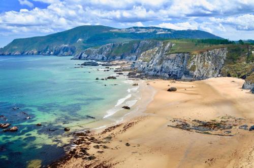 an aerial view of a beach with rocks and the ocean at The Cliffs - Ortigueira Kalmak in Santa Marta de Ortigueira
