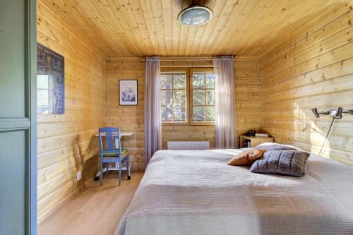 a bedroom with a bed in a wooden cabin at Villa Mörhön Maja - Valkea Homes in Pelkosenniemi