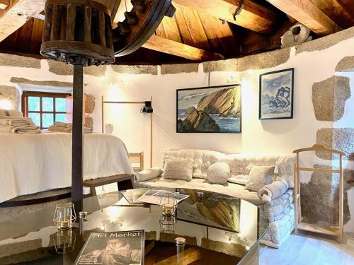 a living room with a couch and a bed at The Cliffs - The Painted Mill in O Barqueiro