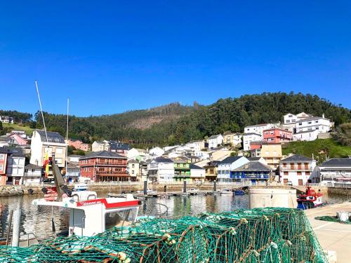 a boat is docked in a harbor with a town at The Cliffs - The Painted Mill in O Barqueiro