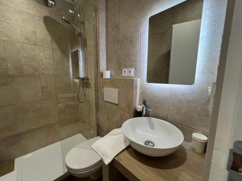 a bathroom with a sink and a toilet and a shower at Adonis Sanary Grand Hôtel des Bains in Sanary-sur-Mer