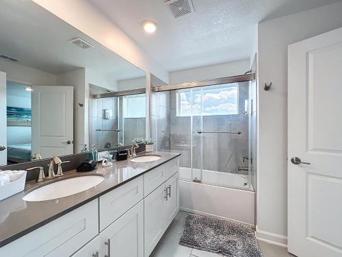 a bathroom with two sinks and a shower at Luxury Pool Home Near Disney Resort Access in Kissimmee