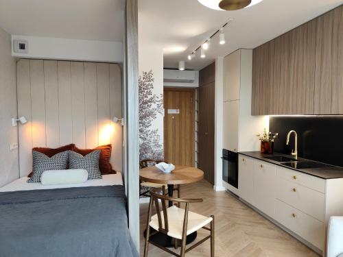 a bedroom with a bed and a table and a kitchen at EASY RENT Apartments - Unia Art Residence 127, Basen & SPA, Centrum 24h Check-in in Lublin