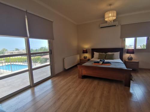 a bedroom with a bed and a large window at Orchard Blossom Private Villa With Pool in Phrenaros