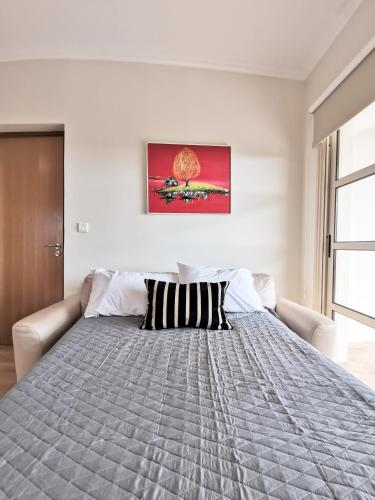 a bedroom with a large bed with a gray blanket at Orchard Blossom Private Villa With Pool in Phrenaros