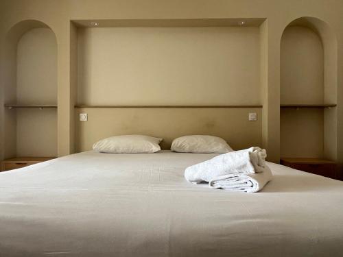 a bed with two pillows and two towels on it at Adonis Sanary Grand Hôtel des Bains in Sanary-sur-Mer