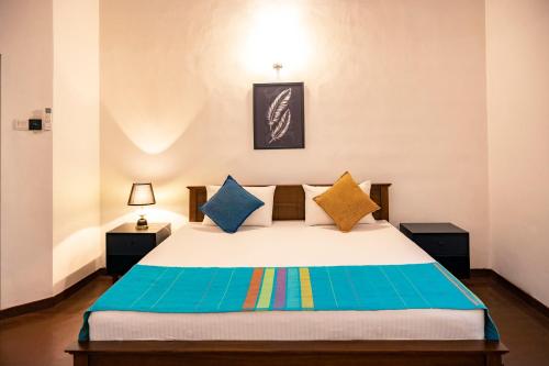 a bedroom with a bed with colorful pillows at Tranquil & Elegant Stay Near Parliament in Talangama South