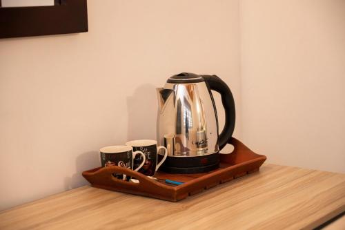 a coffee maker on a wooden shelf with two cups at Tranquil & Elegant Stay Near Parliament in Talangama South