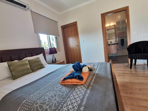 a bedroom with a bed with a stuffed animal on it at Orchard Blossom Private Villa With Pool in Phrenaros