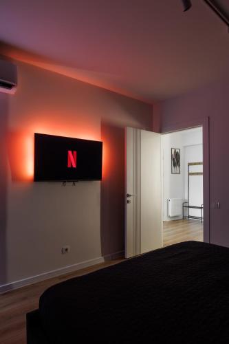 a bedroom with a n sign on the wall at 1,5 BR- Balcony, Netflix, Nespresso, AC, Walk-to-Mall - GrandStay md in Sectorul Botanica