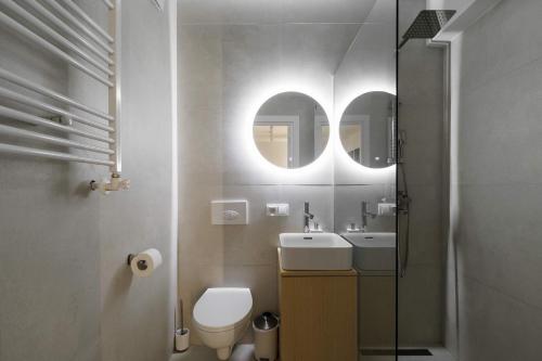 a bathroom with a toilet and a sink and a mirror at 1,5 BR- Balcony, Netflix, Nespresso, AC, Walk-to-Mall - GrandStay md in Sectorul Botanica