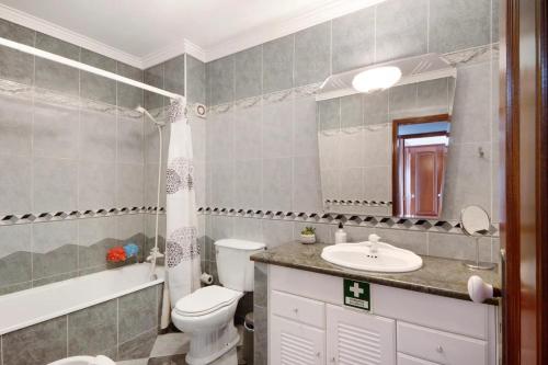 a bathroom with a toilet and a sink and a mirror at Live Vagueira Beach in Praia da Vagueira
