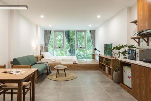 ハノイにあるThe Ivory Dragon Hanoi-Modern Stay with Private Balcony-Free Laundryのソファとベッドのあるリビングルーム