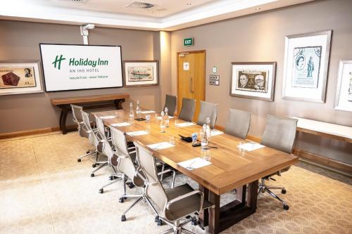 a conference room with a large wooden table and chairs at Holiday Inn Mauritius Mon Trésor by IHG in Blue Bay
