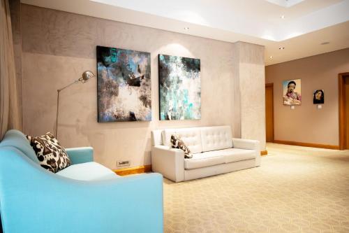 a living room with a couch and paintings on the wall at Holiday Inn Mauritius Mon Trésor by IHG in Blue Bay