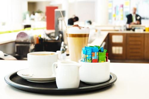 a tray with two coffee cups and a drink at Holiday Inn Mauritius Mon Trésor by IHG in Blue Bay
