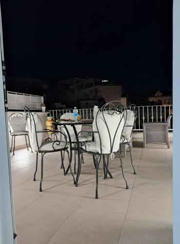 three chairs and a table on a balcony at Casa vacanze Vista Castello in Oria