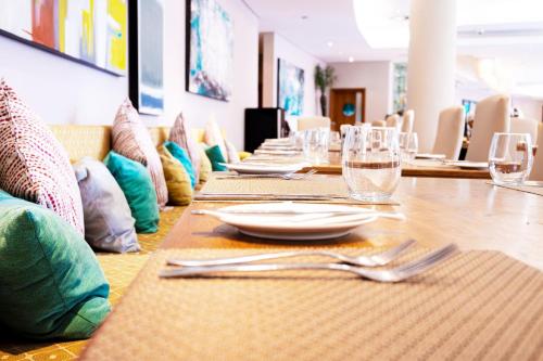 a long table with plates and wine glasses on it at Holiday Inn Mauritius Mon Trésor by IHG in Blue Bay