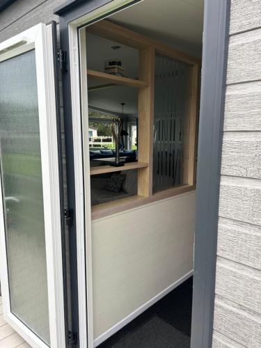 a sliding glass door of a house with a window at Blissful Lodge Haven Lakeland in Flookburgh
