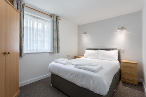 a bedroom with a bed with two towels on it at North Devon Getaways in Ilfracombe