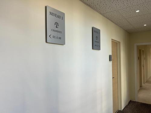 two signs on a wall in a hallway at Adonis Sanary Grand Hôtel des Bains in Sanary-sur-Mer