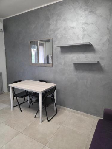 Habitación con mesa y espejo en la pared. en Ceriale Suite, en Ceriale