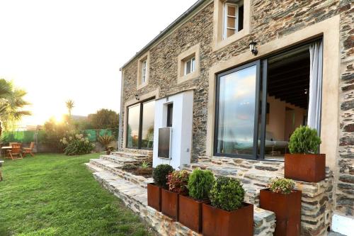 a stone house with plants on the side of it at The Cliffs - Picon Seaside Cottage in Loiba