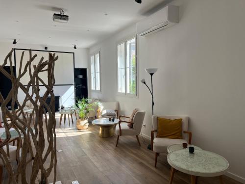 a living room with white walls and wooden floors at Adonis Sanary Grand Hôtel des Bains in Sanary-sur-Mer