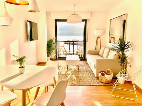 a living room with a couch and a table and chairs at The Cliffs - Sunset Village Beach 3C in Viveiro