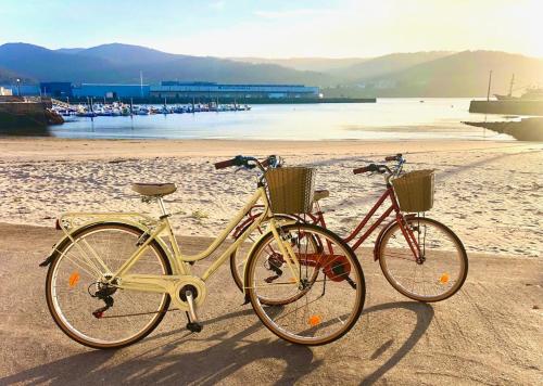 two bikes parked on a beach near the water at The Cliffs - Sunset Village Beach 3C in Viveiro