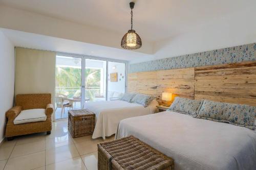 una habitación de hotel con dos camas y una silla en Beachfront 4beds Jacuzzi Privacy Full Kitchen, en La Puntica de Juan Dolio