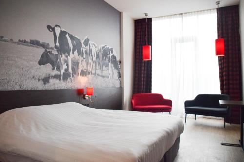 a hotel room with a bed and a red chair at Bastion Hotel Almere in Almere