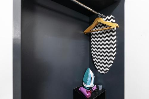 a room with a black wall with a hat and a shelf at Magic Stay Rooms in London
